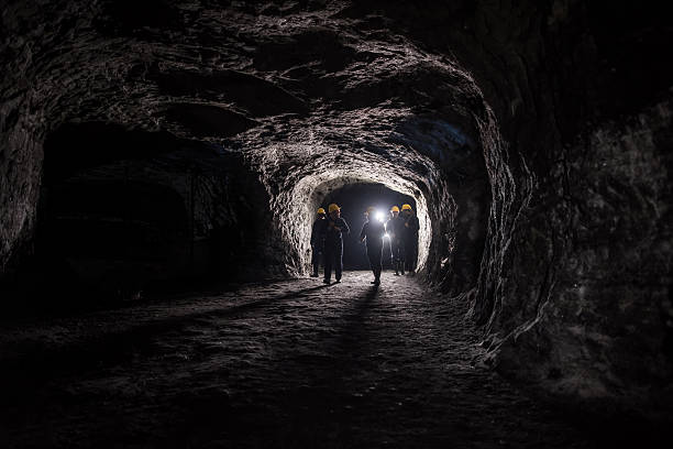 Group of men in a dark mine underground - mining concepts